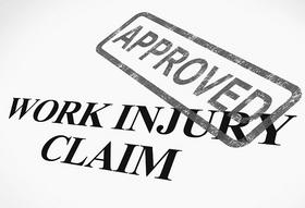 A work injury claim approved stamp on top of papers.