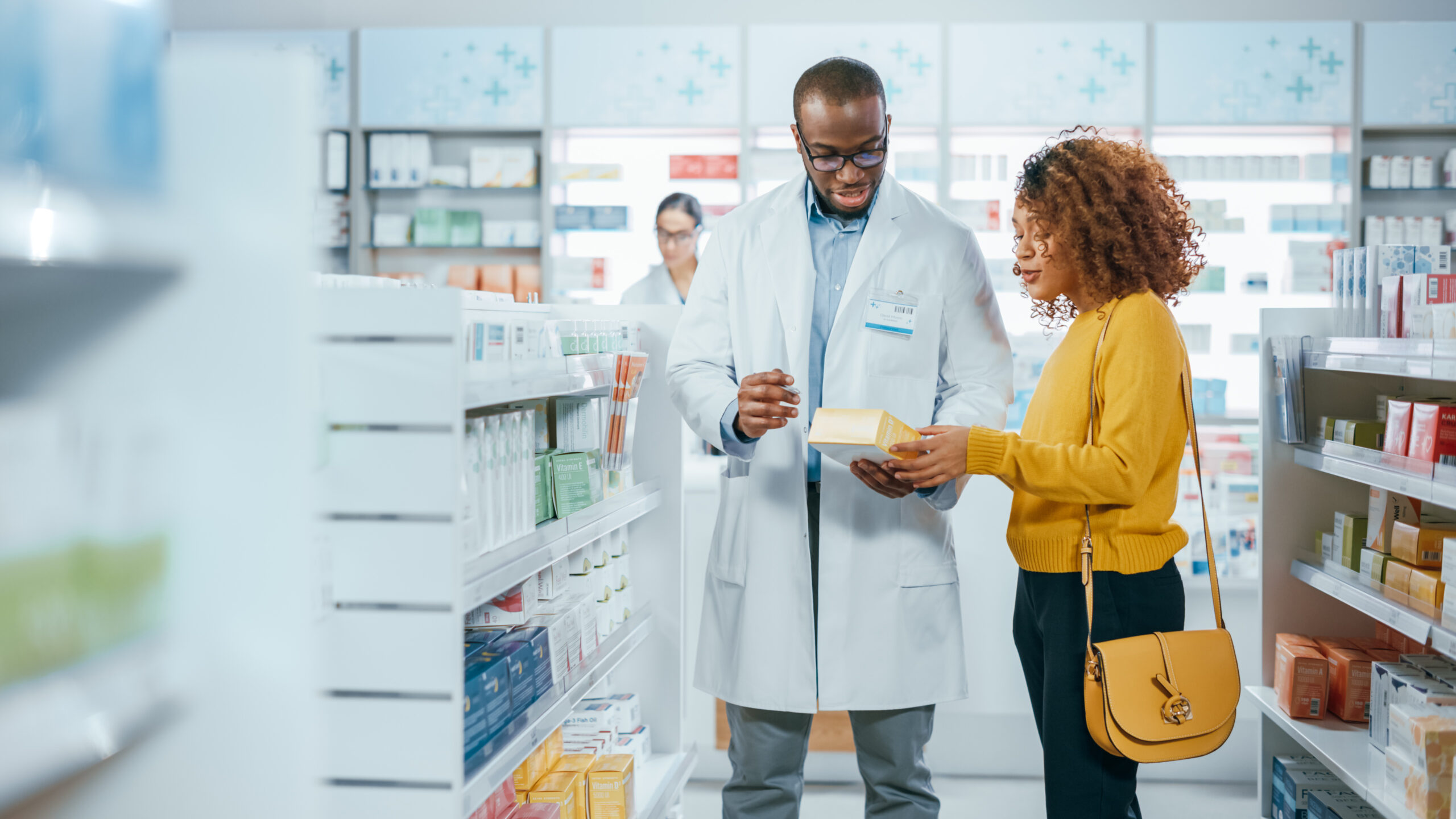 A man in white coat holding a phone near woman.