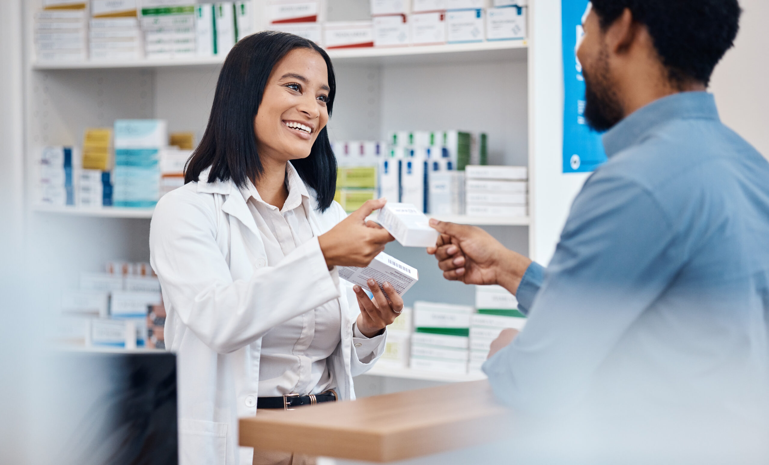 A woman is handing a man some medicine.