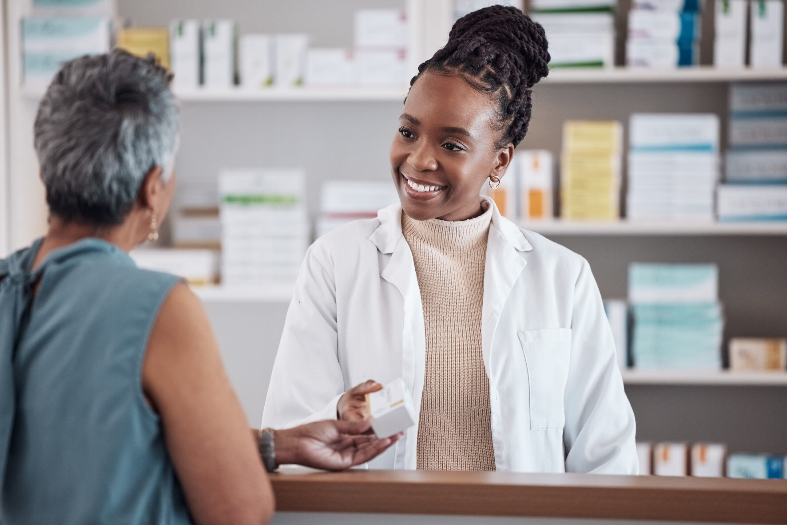 A woman is talking to someone in the pharmacy.